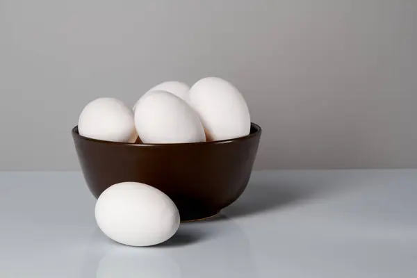 Huevos de pollo blancos en un plato sobre un fondo blanco. Vista lateral . — Foto de Stock