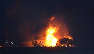 Bu, patlamalı büyük bir gece yangını kazasının fotoğrafı. Tehlikeli kargo taşıyan bir kamyon patladı ve alev aldı. İtfaiyeciler yangınla savaşmaya başlayın.. 