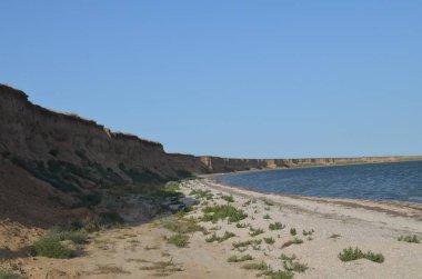 Sahilin yakınında bulunan sarp, dik, ıssız bir su deposunun kıyısı. Arkaplan görevi görebilir.