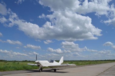 Havalimanında, güzel yaz bulutlarının arkasında, açık beyaz bir uçağın fotoğrafı. Arka plan olabilir..