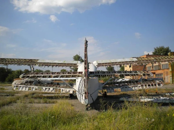 The photo shows the plane on which it is necessary to carry out repairs. The material on the wings of the aircraft in poor condition, is torn off. .Photo taken in summer, in fine, sunny weather.