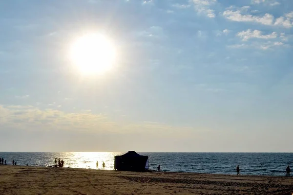 Very early morning on the sea beach. Rare visitors walk along the shore, some are already taking sea baths.