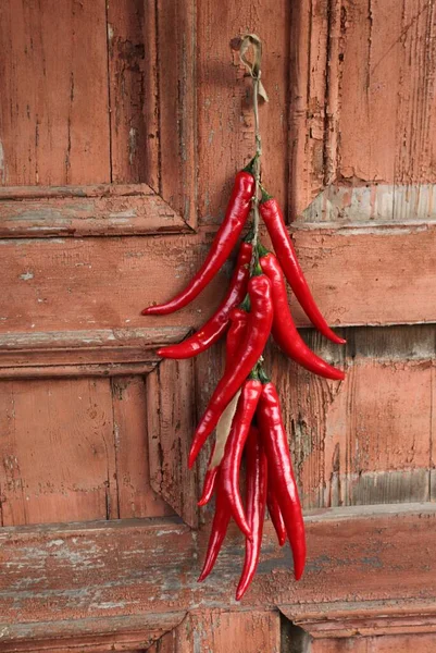 Peperoncino Rosso Appeso Viene Fotografato Sullo Sfondo Vecchio Muro Legno — Foto Stock