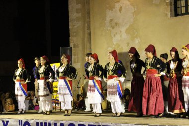 Chania, Girit Adası, Yunanistan - 3 Ağustos 2016: Geleneksel Girit kostümlü dansçılar, yaz festivali sırasında eski Venedik Limanı 'nda sahne alıyorlar.