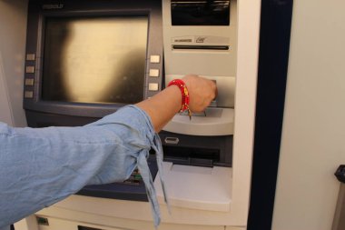 Milan, İtalya - 16 Nisan 2017: Bir kadın ATM 'den para çekiyor, sağ kolunu ve elini Dante Caddesi' nde gösteriyor.