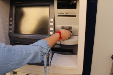 Milan, İtalya - 16 Nisan 2017: Bir kadın ATM 'den para çekiyor, sağ kolunu ve elini Dante Caddesi' nde gösteriyor.