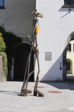 Bludenz, Vorarlberg, Avusturya - 30 Nisan 2017: Herrengasse ve Mutterstrasse köşesinde taş, metal ve ahşap parçalardan yapılmış bir çanta ve yüksek topuklu ayakkabı ile soyut bir kadın heykeli.