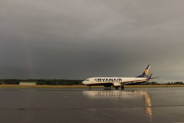 Memmingen, Almanya - 24 Temmuz 2017: Yağmurlu bir günde Allgau havaalanında gerçek bir gökkuşağı arka planına sahip Ryan Air uçağı yeni indi.