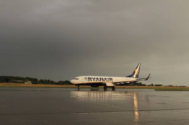 Memmingen, Almanya - 24 Temmuz 2017: Yağmurlu bir günde Allgau havaalanında gerçek bir gökkuşağı arka planına sahip Ryan Air uçağı yeni indi.