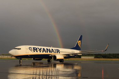 Memmingen, Almanya - 24 Temmuz 2017: Yağmurlu bir günde Allgau havaalanında gerçek bir gökkuşağı arka planına sahip Ryan Air uçağı yeni indi.