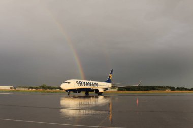 Memmingen, Almanya - 24 Temmuz 2017: Yağmurlu bir günde Allgau havaalanında gerçek bir gökkuşağı arka planına sahip Ryan Air uçağı yeni indi.