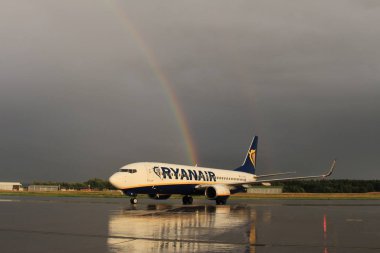 Memmingen, Almanya - 24 Temmuz 2017: Yağmurlu bir günde Allgau havaalanında gerçek bir gökkuşağı arka planına sahip Ryan Air uçağı yeni indi.