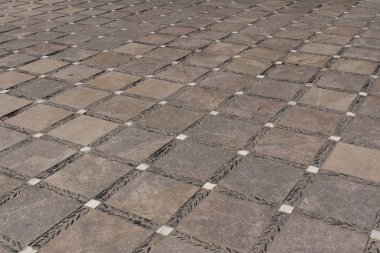 Arkaplan olarak yerdeki taş mozaik fayanslar.