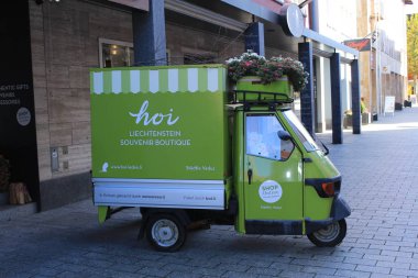 Vaduz, Lihtenştayn - 1 Kasım 2017: Staedtle Caddesi 'ndeki Hoi Hatıra Butiği tarafından çiçek ve hediyelerle süslenmiş yeşil tuktuk.