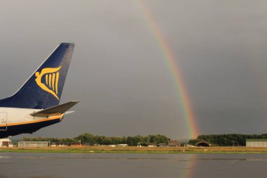 Memmingen, Almanya - 24 Temmuz 2017: Yağmurlu bir günde Allgau havaalanında gerçek bir gökkuşağı arka planına sahip Ryan Air uçak kuyruğu logosu.