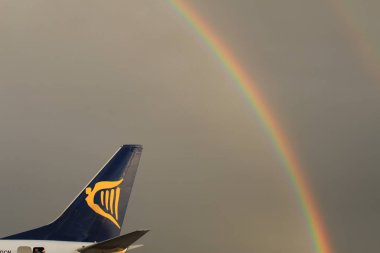Memmingen, Almanya - 24 Temmuz 2017: Yağmurlu bir günde Allgau havaalanında gerçek bir gökkuşağı arka planına sahip Ryan Air uçak kuyruğu logosu.
