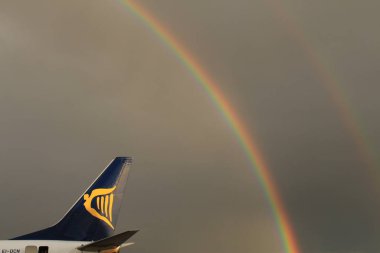 Memmingen, Almanya - 24 Temmuz 2017: Yağmurlu bir günde Allgau havaalanında gerçek bir gökkuşağı arka planına sahip Ryan Air uçak kuyruğu logosu.