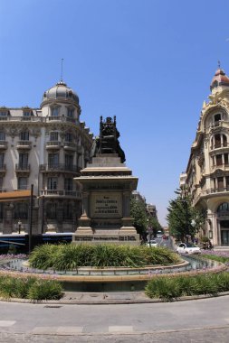 Granada, Endülüs, İspanya - 27 Temmuz 2017: Kraliçe Isabella 'nın anıtı Gotik bir tahtta oturmuş, Kolomb' un planlarını dinliyordu, Plaza Isabel la Catolica Meydanı 'nda önünde duruyordu..