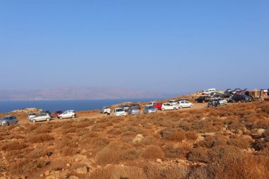 Gramvousa, Girit Adası, Yunanistan - 29 Temmuz 2016: Turistler arabalarını ünlü Balos plajına giden bir tepeye park ettiler.