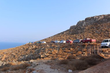Gramvousa, Girit Adası, Yunanistan - 29 Temmuz 2016: Turistler arabalarını ünlü Balos plajına giden bir tepeye park ettiler.