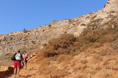 Gramvousa, Girit Adası, Yunanistan - 29 Temmuz 2016: Turistler kavurucu güneşin altında uzun bir yolculuktan sonra ünlü Balos plajına ulaşmaya çalışıyorlar.