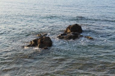Mediterranean sea waves splashing at the rocks with foam in Chania, Crete Island, Greece.