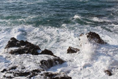 Mediterranean sea waves splashing at the rocks with foam in Chania, Crete Island, Greece.
