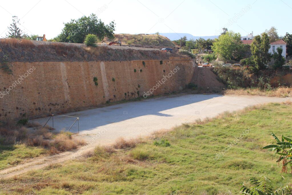 Historical West Venetian Walls and soil pitch for soccer near old Venetian San Salvatore Bastion in Chania, Crete island, Greece.