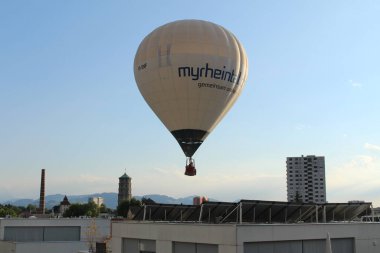 BREGENZ, VORARLBERG, AUSTRIA - 28 Haziran 2016: Mariahilfstrasse Caddesi etrafındaki binaların üzerinde iki kişiyi taşıyan sıcak hava balonu uçuyor.