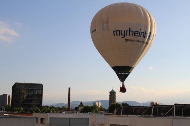BREGENZ, VORARLBERG, AUSTRIA - 28 Haziran 2016: Mariahilfstrasse Caddesi etrafındaki binaların üzerinde iki kişiyi taşıyan sıcak hava balonu uçuyor.