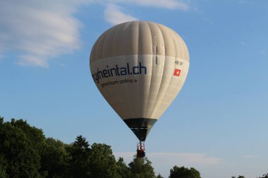 BREGENZ, VORARLBERG, AUSTRIA - 28 Haziran 2016: Mariahilfstrasse Caddesi etrafındaki binaların üzerinde iki kişiyi taşıyan sıcak hava balonu uçuyor.