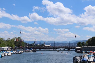 ZURİH, SWitzERLAND - 3 Temmuz 2016: Sanatçılar, Zürih Şehir Festivali sırasında Limmat Nehri boyunca demirlemiş halatla dengede duruyorlar (Zueri Faescht).