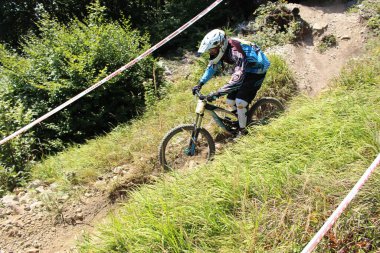 INNSBRUCK, AUSTRIA - 29 Ağustos 2015: Nordkette Alp dağ zincirinde Nordkette Downhill Pro yarışması sırasında tam donanımlı profesyonel motorcu dağ bisikleti sürüyor.