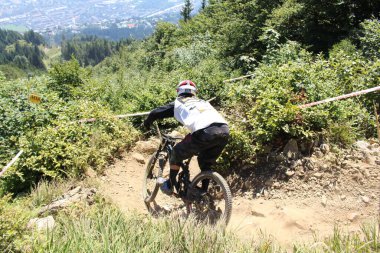 INNSBRUCK, AUSTRIA - 29 Ağustos 2015: Nordkette Alp dağ zincirinde Nordkette Downhill Pro yarışması sırasında tam donanımlı profesyonel motorcu dağ bisikleti sürüyor.