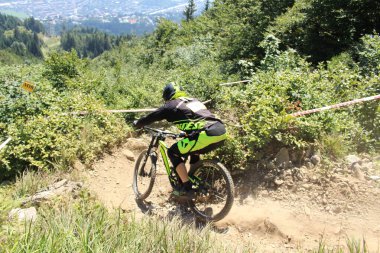 INNSBRUCK, AUSTRIA - 29 Ağustos 2015: Nordkette Alp dağ zincirinde Nordkette Downhill Pro yarışması sırasında tam donanımlı profesyonel motorcu dağ bisikleti sürüyor.