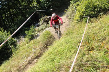 INNSBRUCK, AUSTRIA - 29 Ağustos 2015: Nordkette Alp dağ zincirinde Nordkette Downhill Pro yarışması sırasında tam donanımlı profesyonel motorcu dağ bisikleti sürüyor.