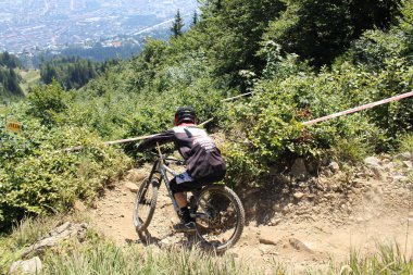 INNSBRUCK, AUSTRIA - 29 Ağustos 2015: Nordkette Alp dağ zincirinde Nordkette Downhill Pro yarışması sırasında tam donanımlı profesyonel motorcu dağ bisikleti sürüyor.