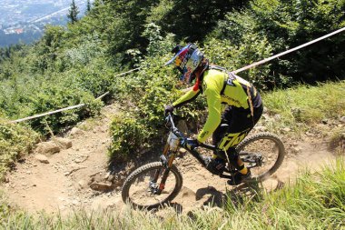 INNSBRUCK, AUSTRIA - 29 Ağustos 2015: Nordkette Alp dağ zincirinde Nordkette Downhill Pro yarışması sırasında tam donanımlı profesyonel motorcu dağ bisikleti sürüyor.