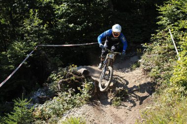 INNSBRUCK, AUSTRIA - 29 Ağustos 2015: Nordkette Alp dağ zincirinde Nordkette Downhill Pro yarışması sırasında tam donanımlı profesyonel motorcu dağ bisikleti sürüyor.
