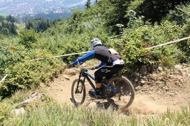INNSBRUCK, AUSTRIA - 29 Ağustos 2015: Nordkette Alp dağ zincirinde Nordkette Downhill Pro yarışması sırasında tam donanımlı profesyonel motorcu dağ bisikleti sürüyor.