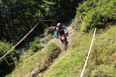 INNSBRUCK, AUSTRIA - 29 Ağustos 2015: Nordkette Alp dağ zincirinde Nordkette Downhill Pro yarışması sırasında tam donanımlı profesyonel motorcu dağ bisikleti sürüyor.