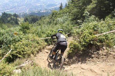 INNSBRUCK, AUSTRIA - 29 Ağustos 2015: Nordkette Alp dağ zincirinde Nordkette Downhill Pro yarışması sırasında tam donanımlı profesyonel motorcu dağ bisikleti sürüyor.