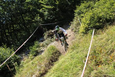 INNSBRUCK, AUSTRIA - 29 Ağustos 2015: Nordkette Alp dağ zincirinde Nordkette Downhill Pro yarışması sırasında tam donanımlı profesyonel motorcu dağ bisikleti sürüyor.