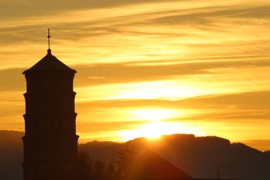 Mariahilf Kilisesi (başlangıçta Pfarrkirche Mariahilf veya Heldendankkirche) Bregenz, Vorarlberg, Avusturya 'da Mariahilf Caddesi' nde günbatımında bulunan kule..