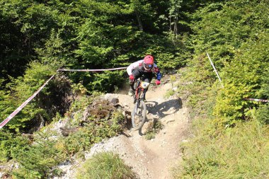 INNSBRUCK, AUSTRIA - 29 Ağustos 2015: Nordkette Alp dağ zincirinde Nordkette Downhill Pro yarışması sırasında tam donanımlı profesyonel motorcu dağ bisikleti sürüyor.