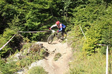 INNSBRUCK, AUSTRIA - 29 Ağustos 2015: Nordkette Alp dağ zincirinde Nordkette Downhill Pro yarışması sırasında tam donanımlı profesyonel motorcu dağ bisikleti sürüyor.