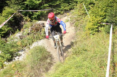 INNSBRUCK, AUSTRIA - 29 Ağustos 2015: Nordkette Alp dağ zincirinde Nordkette Downhill Pro yarışması sırasında tam donanımlı profesyonel motorcu dağ bisikleti sürüyor.
