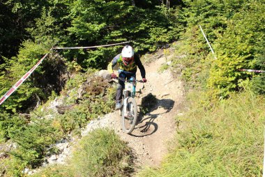 INNSBRUCK, AUSTRIA - 29 Ağustos 2015: Nordkette Alp dağ zincirinde Nordkette Downhill Pro yarışması sırasında tam donanımlı profesyonel motorcu dağ bisikleti sürüyor.