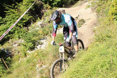 INNSBRUCK, AUSTRIA - 29 Ağustos 2015: Nordkette Alp dağ zincirinde Nordkette Downhill Pro yarışması sırasında tam donanımlı profesyonel motorcu dağ bisikleti sürüyor.