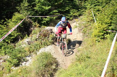 INNSBRUCK, AUSTRIA - 29 Ağustos 2015: Nordkette Alp dağ zincirinde Nordkette Downhill Pro yarışması sırasında tam donanımlı profesyonel motorcu dağ bisikleti sürüyor.